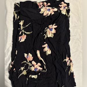 Black pants with white flowers on them.